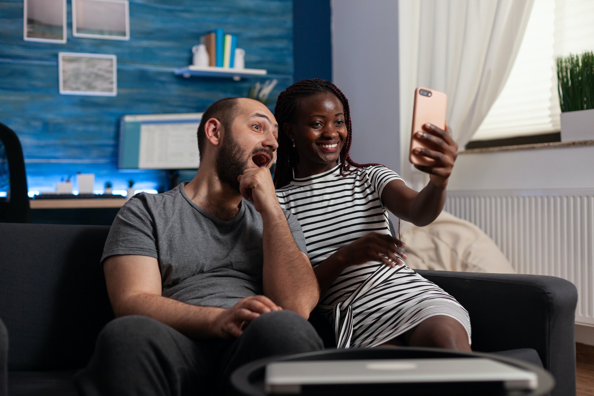 Interracial couple holding smartphone for pictures