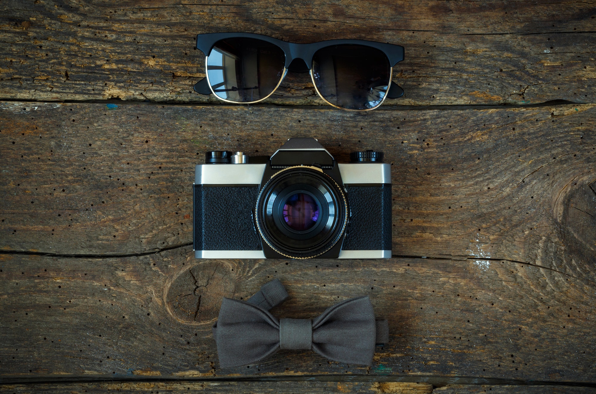Sunglasses, old-fashioned camera and bow tie