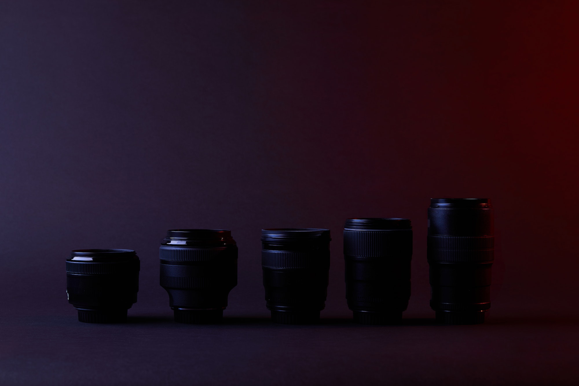 different camera lenses on dark surface